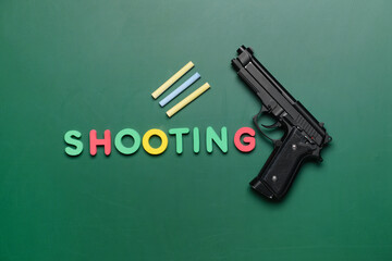 Pistol and chalk on blackboard. Concept of school shooting