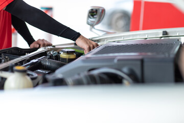 Professional car mechanic checking and maintenance service in gas station. Power to drive vehicles and gas station pump concept.