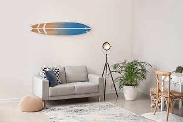 Interior of modern stylish room with surfboard and sofa