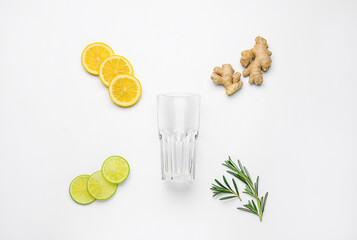Composition with glass and healthy citrus fruits on white background