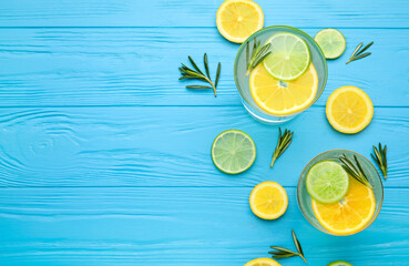 Glasses of healthy lemonade on color wooden background
