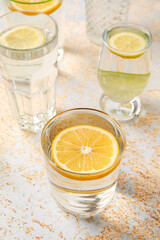 Glasses of healthy lemonade on light background
