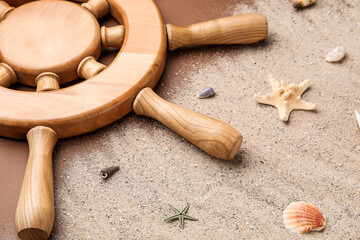 Helm, sand and sea shells on color background