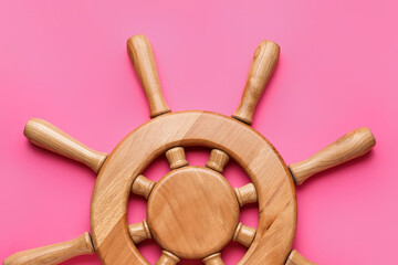 Ship helm on color background