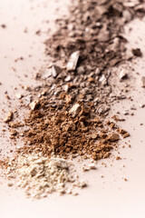 broken eye shadow scattered across the smooth pink surface. Texture background, advertising the structure of cosmetics. macro, copyspace