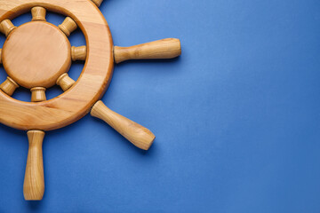 Ship helm on color background