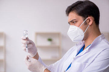 Young male doctor in vaccination concept