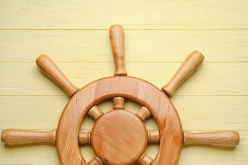 Ship helm on wooden background