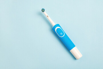 electric toothbrush on a blue background. top view and copy space