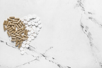 Heart shape made of pills on light background
