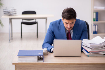 Young male employee and too much work in the office
