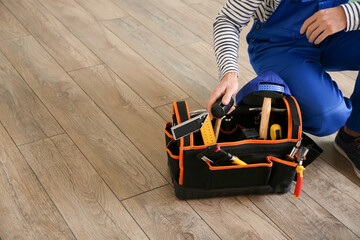 Obraz premium Carpenter during installing of laminate flooring in room