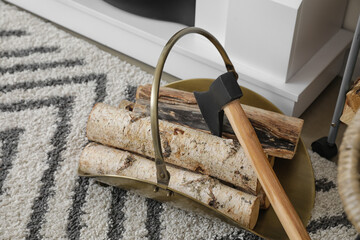 Axe with firewood on floor near fireplace