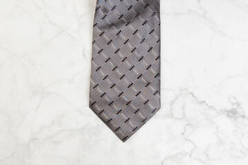 Gray tie on marble background.