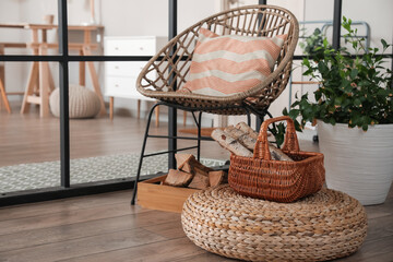 Wicker armchair and firewood in room