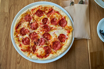Top view of Pepperoni pizza on plate on the table