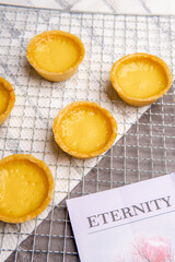The egg tart  is a kind of custard tart found in Cantonese cuisine derived from the English custard tart and Portuguese pastel de nata. Egg tarts are often served at dim sum restaurants and cha chaan 