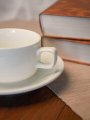 The concept of teaching education with the opening of a book or textbook in the library. a cup of fresh coffee on the table.