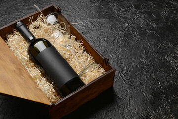 Obraz na płótnie Canvas Box with bottle of wine on dark background
