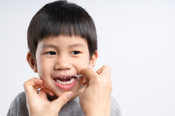 Asian boy about 4 years old is being cleaned teeth with dental floss - obrazy, fototapety, plakaty