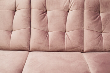 Cropped photo of pink velour sofa . Pink background. Pink monochrome color. Close-up.