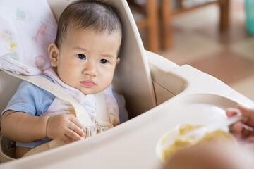6 months old Asian baby eating food