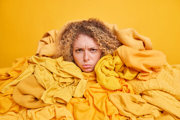 Displeased female volunteer collects clothes for donation charity organization overwhelmed with big...