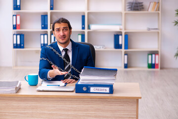Chained male employee unhappy with excessive work in the ofiice