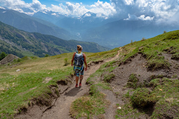 Female hiker climbing the alps while on photography and camping trip