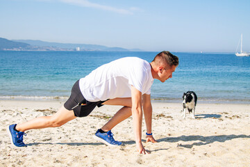 young man in starting position for jogging on the beach