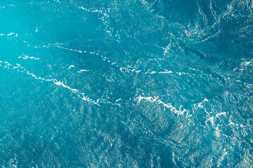 Turquoise ocean water background. Surface of the sea. Natural texture of blue foaming sea water.