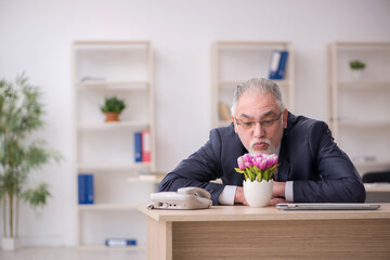 Old businessman florist sitting in the office