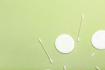 Cotton pads and swabs on color background