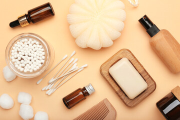 Composition with cotton swabs, balls and cosmetic products on color background