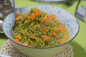 Warm salad of cooked peas and carrots, served in a bowl