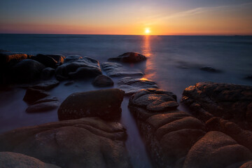 Obraz premium Motion seascape through stone arch at sunset, Rayong