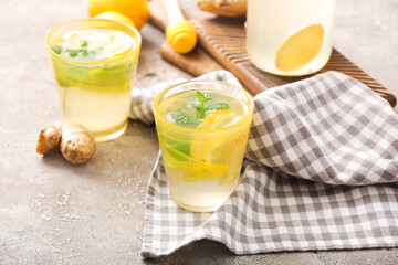 Glass of cold ginger lemonade on grunge background