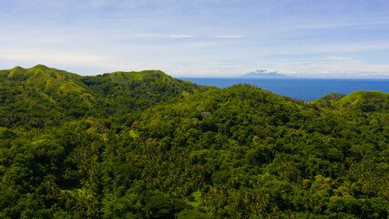 Obraz premium Hills and mountains covered with green grass against a background of blue sky and clouds. Bohol, Philippines. Summer landscape.