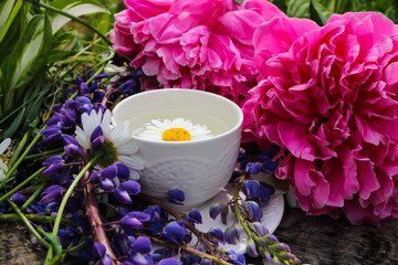 summer morning ,white cup and bouquet of wild flowers