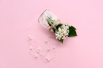 Jar with beautiful gypsophila boutonnieres and beads on color background