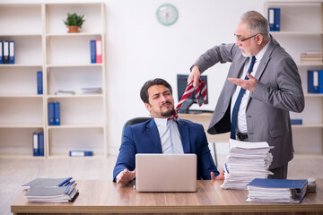 Two male employees working in the office in bullying concept