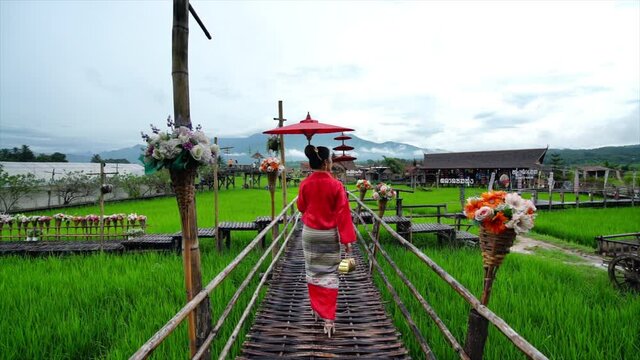 Asian women wearing Thai dress costume traditional according Thai culture at famous place in Nan province, Thailand. Translation: "welcome".