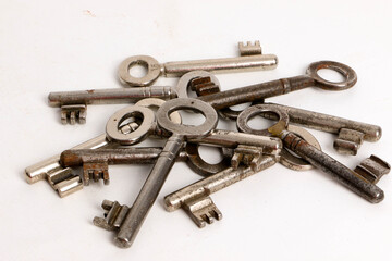 heap of many different old keys are lying in the whiite studio