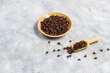 Cubeb pepper in a small bowls and spoon.