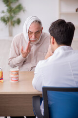 Old male patient visiting young male doctor dentist