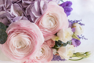 A bouquet of calm tender pink buttercups on the table from side