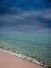 Beach seascape with dramatic clouds over turquoise-colored seawater