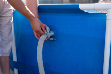 A man checks a filter for cleaning a home pool. Keeping the swimming pool clean