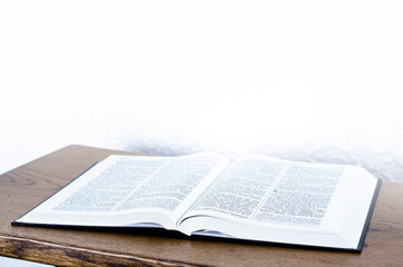 The open book is the holy bible. Light from a book
