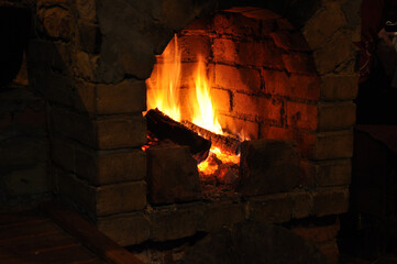 Firewood is burning in the brick fireplace